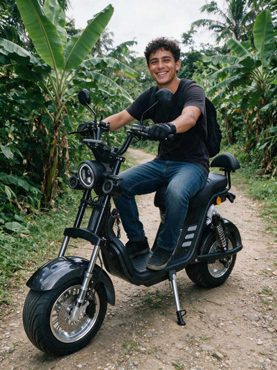 Um homem sorridente de camiseta preta e calça jeans pilotando a scooter elétrica ZORYKEN M8-3000 em uma estrada de terra cercada por vegetação tropical.