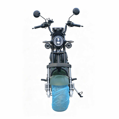 Vista frontal direta da scooter elétrica ZORYKEN M8-3000 verde, destacando o guidão amplo, retrovisores redondos e o potente farol circular de LED aceso.