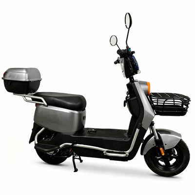 Visão lateral direita da scooter elétrica ZORYKEN Z4 na cor cinza prateada. Destacam-se o baú traseiro cinza instalado no bagageiro, a cesta frontal preta, o amplo estribo plano para os pés, o descanso central acionado e as barras de proteção tubulares na cor prata.