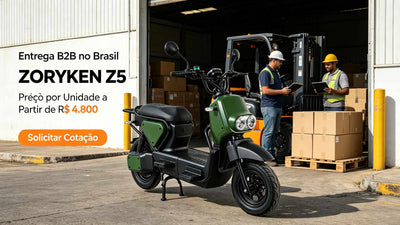 Scooter elétrica ZORYKEN Z5 verde-militar centralizada em frente a um armazém industrial aberto. Ao fundo, dois trabalhadores de capacete de proteção conversam perto de uma empilhadeira com caixas. O texto anuncia "Entrega B2B no Brasil", "Preço por Unidade a Partir de R$ 4.800" e exibe um botão laranja com o texto "Solicitar Cotação".